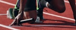 田径运动员在跑道上冲刺的瞬间，背景虚化